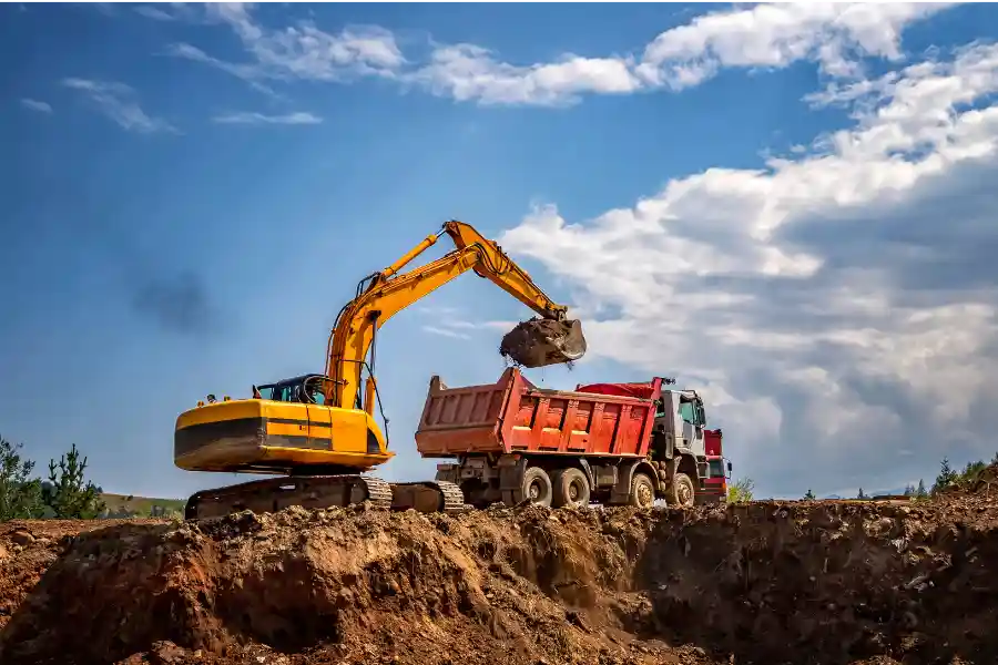 escavatore che scarica terra su camion tre assi Impresa Messina Isola d'Elba